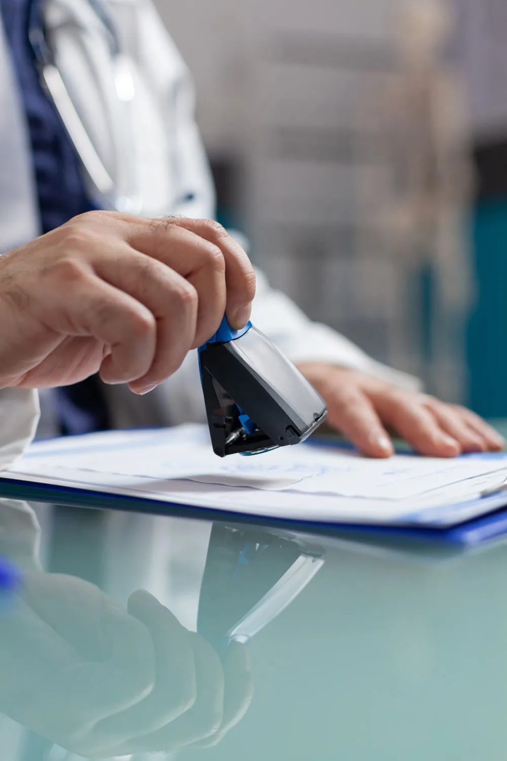 Doctor holding medical stamp to put on prescription paper